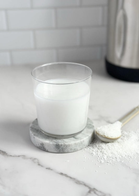 a glass filled with freshly made creamy coconut milk, served in a clear cup